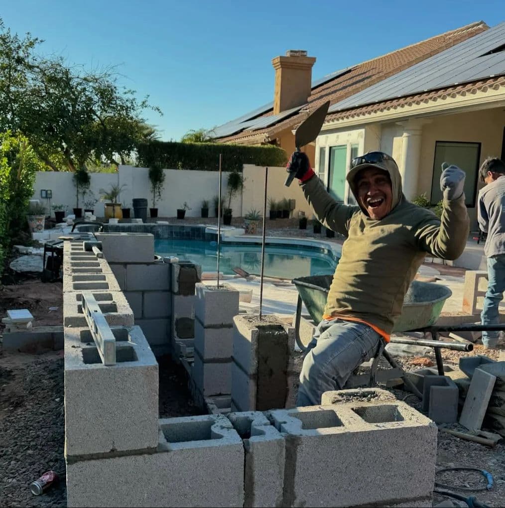 Horizon crew member building a block wall beside a pool