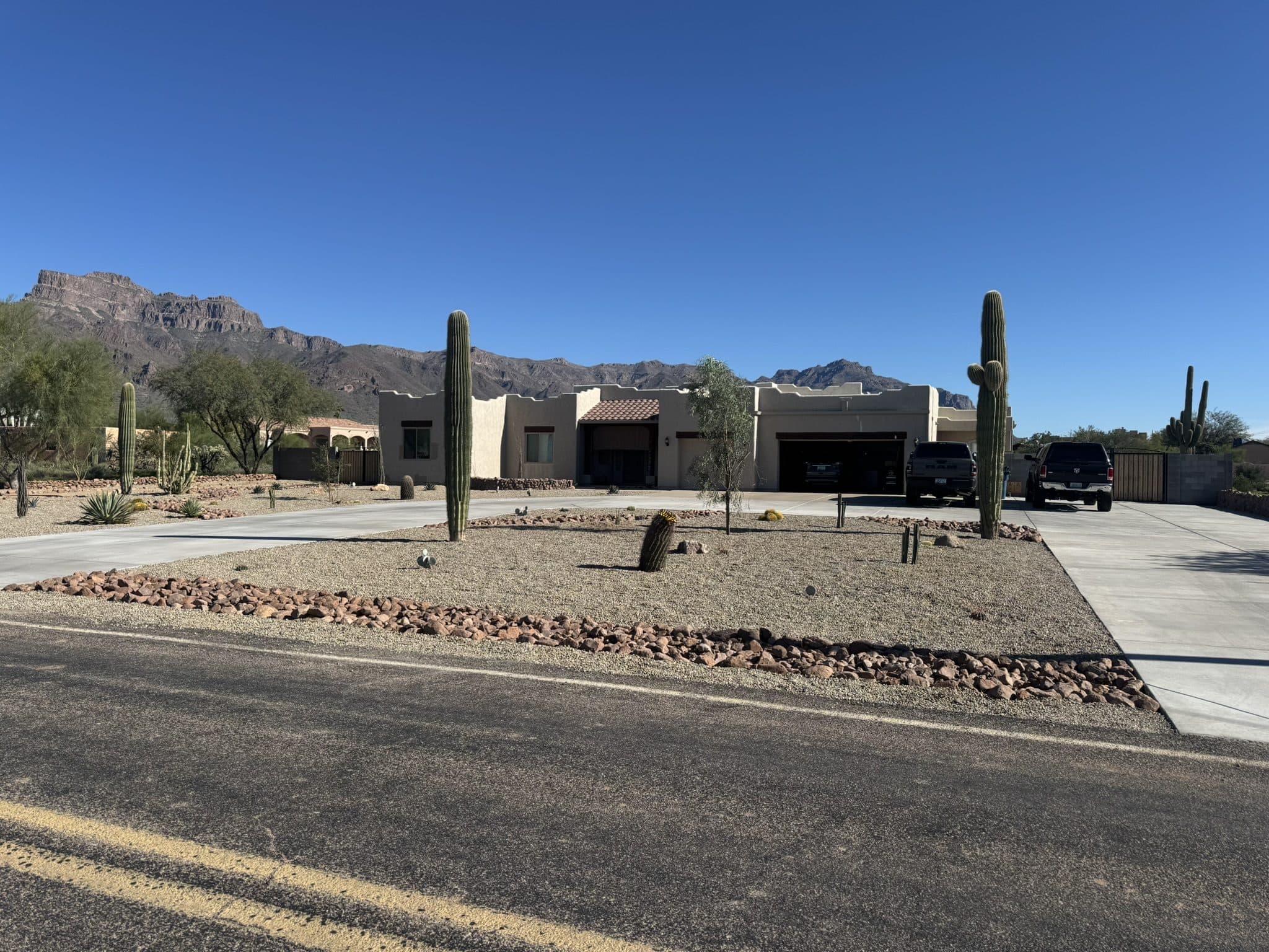 Desert front yard with saguaro, rock borders and the Superstition Mountains behind