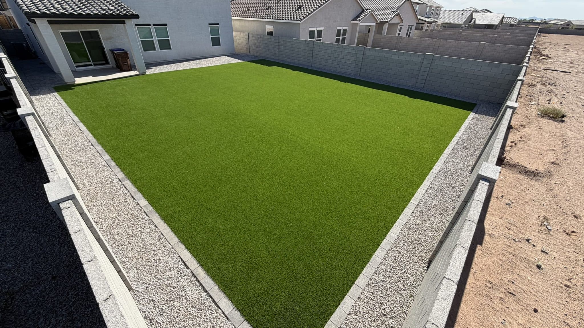 Overhead view of a turf lawn bordered by Phoenix Pavers and mineral gray rock