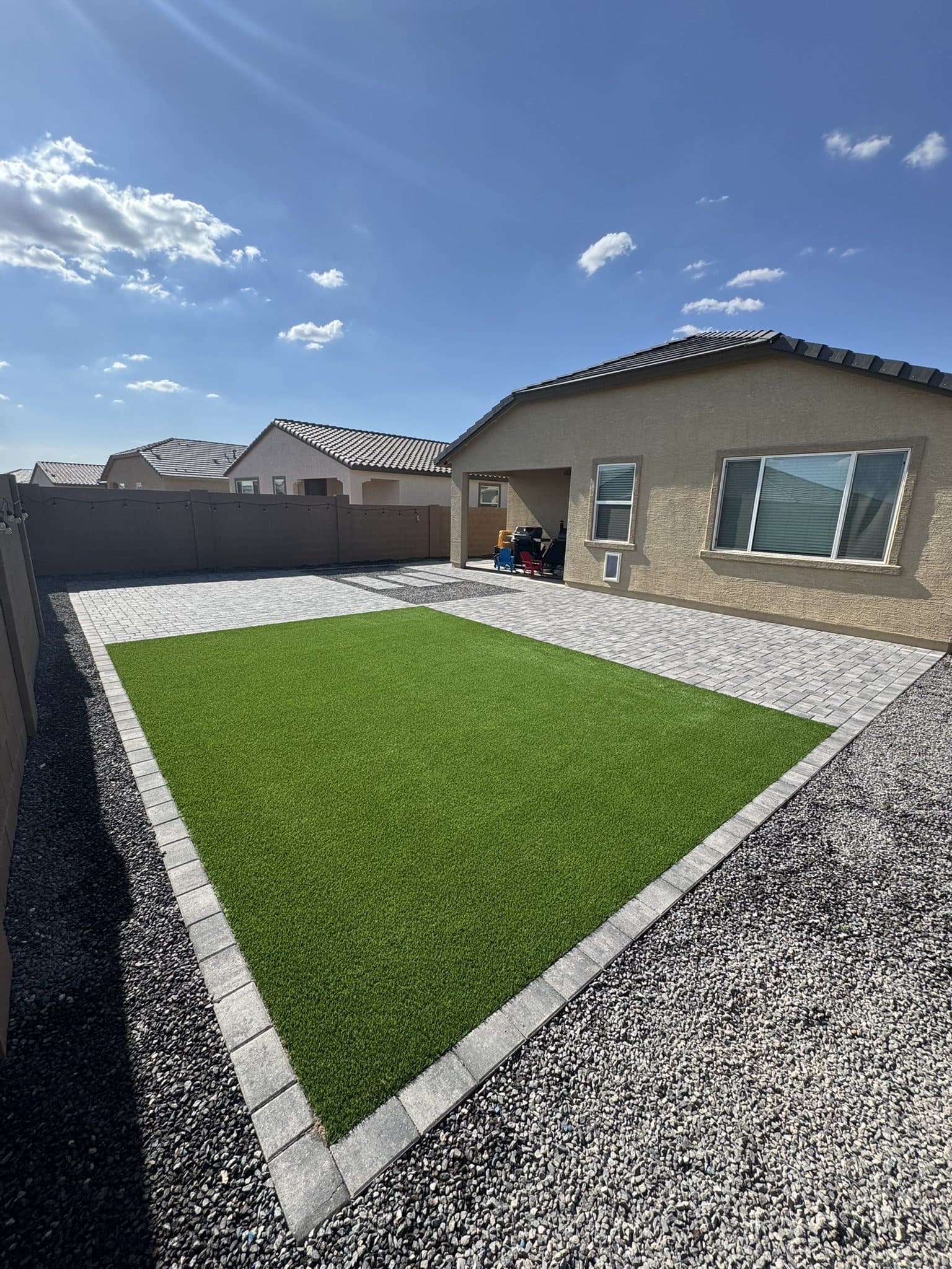 Turf lawn with a Phoenix Pavers border, paver patio and charcoal rock