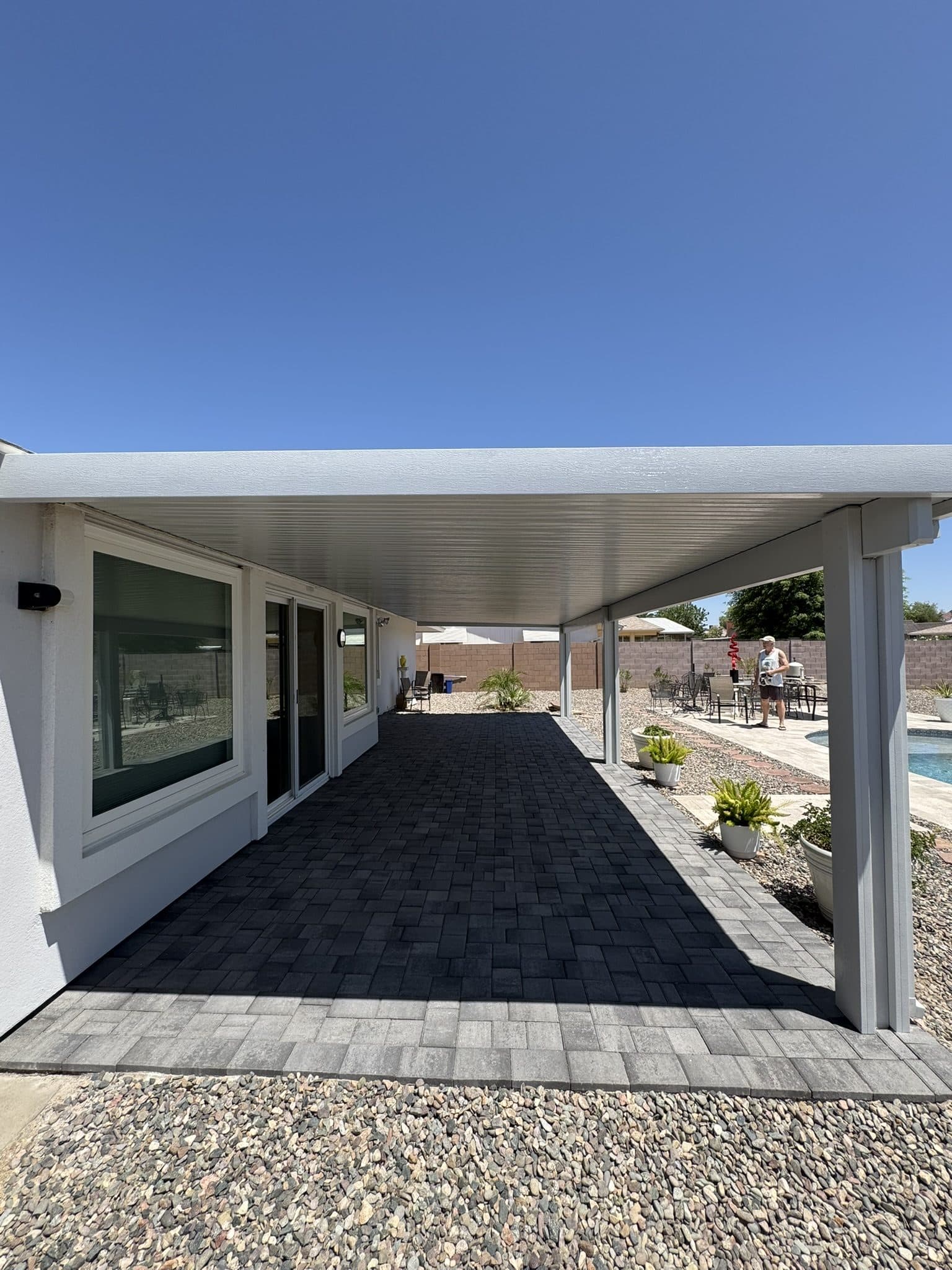 Light gray attached aluminum pergola over a Townscape Slate paver patio